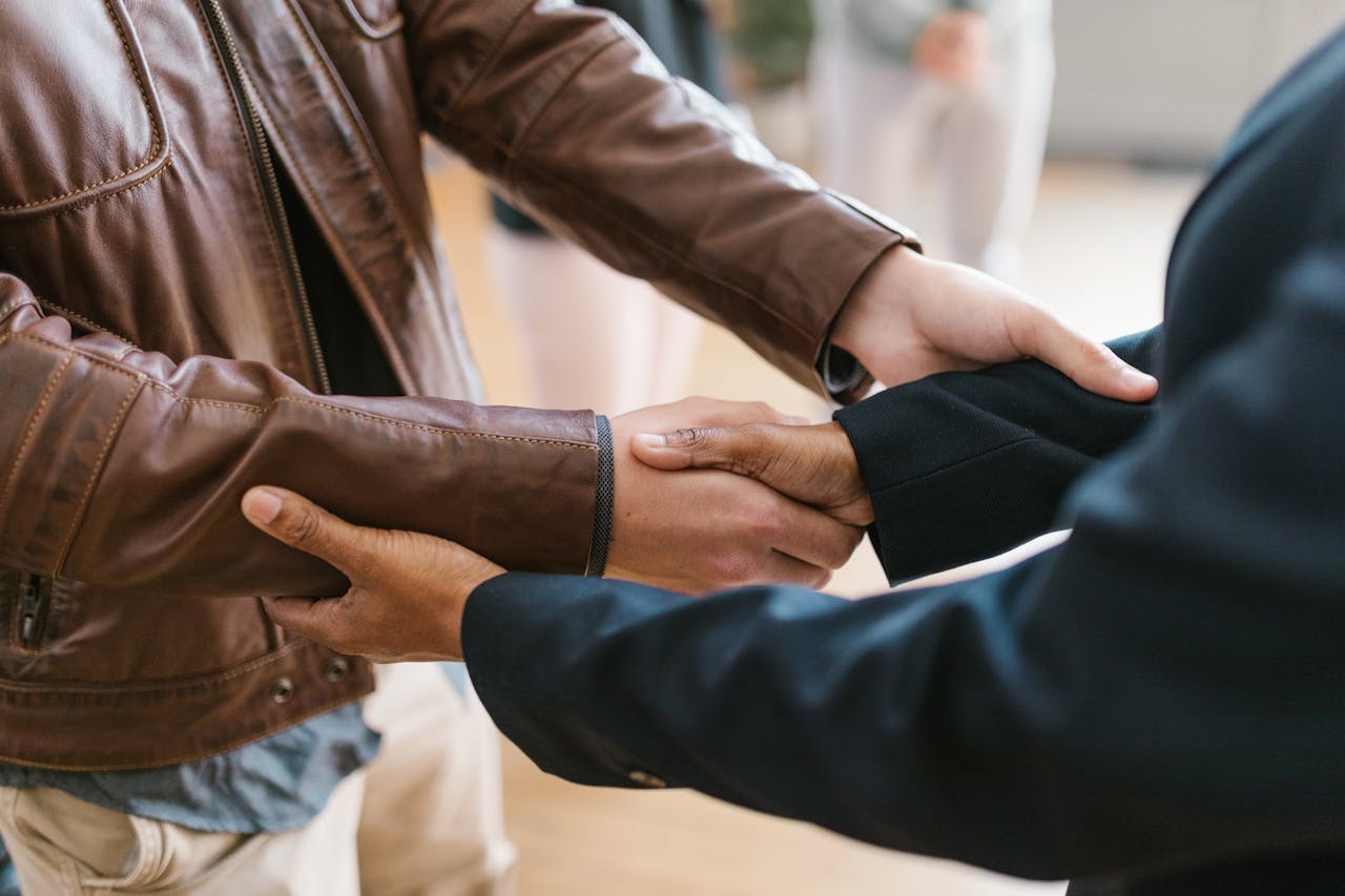 Mastering the First Impression: Your intriguing post title goes here Two business professionals shaking hands, symbolizing teamwork and collaboration indoors.